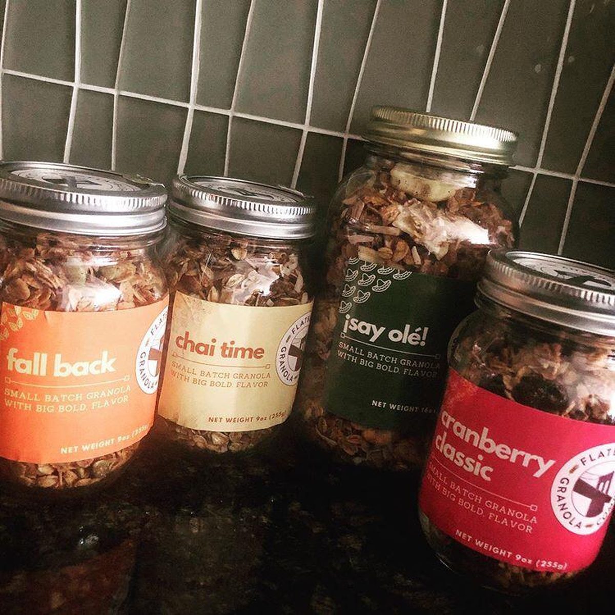 Four Flatbush Granola jars lined up on a kitchen counter