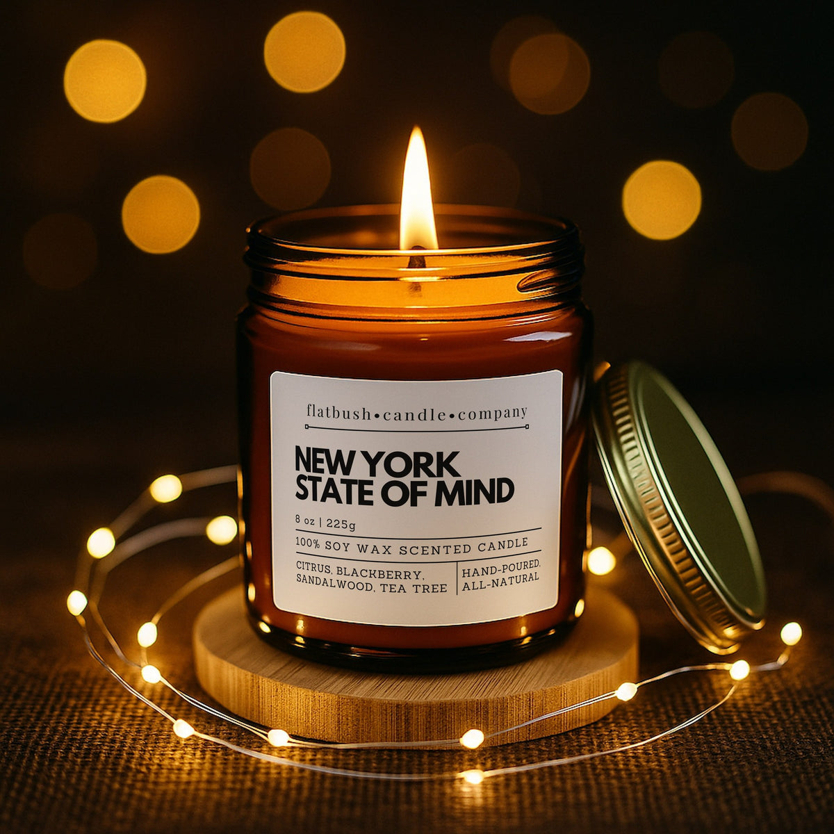 The Signature Candle in New York State of Mind: 9oz hand-poured soy candle by Flatbush Candle Co., lit, with notes of citrus, blackberry, sandalwood and tea tree
